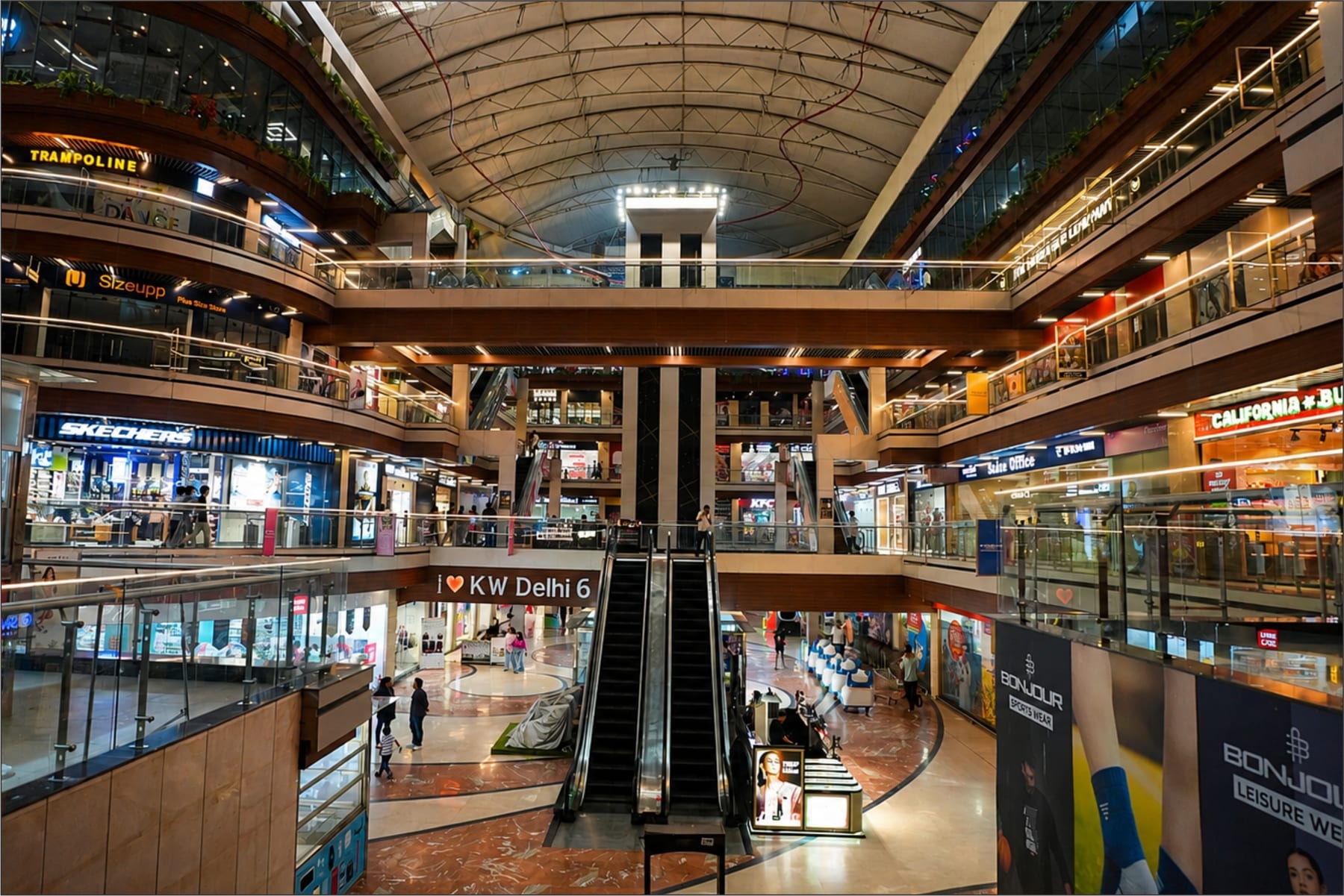 KW Delhi 6 multi-level atrium, escalators and brand storefronts inside the mall